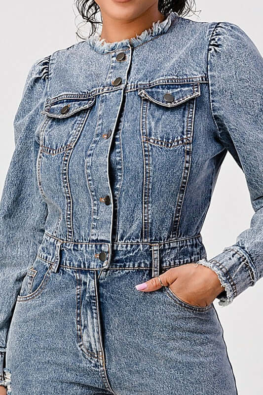 A model wearing a LONG SLEEVE DENIM ROMPER featuring a classic blue wash and cinched waistline.