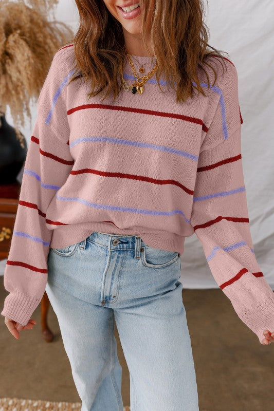 Woman wearing Stripe Ribbed Trim Drop Shoulder Sweater with red and purple stripes, casually styled with jeans.