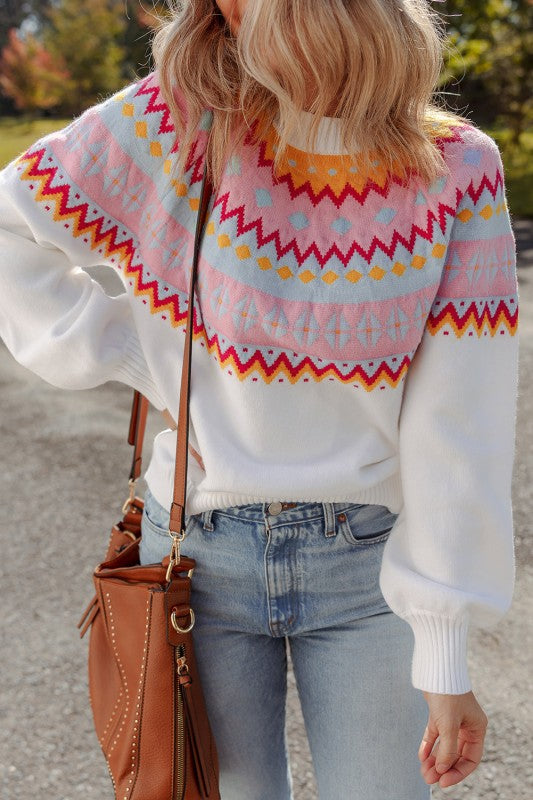 Woman wearing Avery Print Drop Shoulder Sweater with geometric print and colorblock design, paired with jeans and brown handbag.
