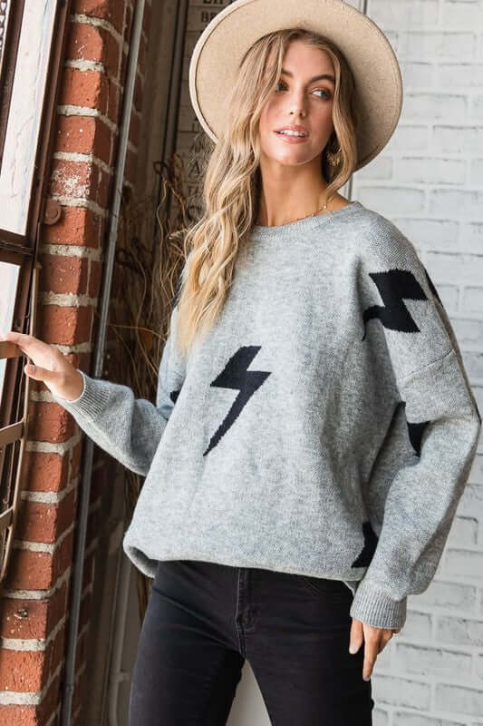 BOLT LONG SLEEVE CREW NECK SWEATER shown on model with a hat, featuring a soft fabric and bold bolt lighting print.
