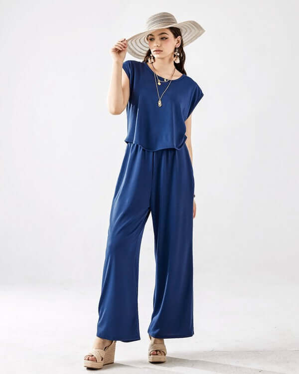 Model wearing Open Front Wide Leg Jumpsuit in blue with a stylish hat, showcasing relaxed fit and chic design.