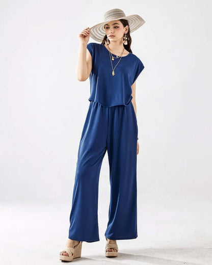 Model wearing Open Front Wide Leg Jumpsuit in blue with a stylish hat, showcasing relaxed fit and chic design.