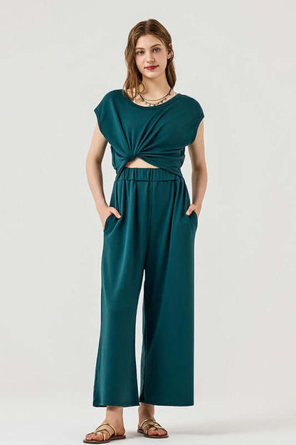 Model wearing Open Front Wide Leg Jumpsuit featuring a trendy twist-front design and side pockets.
