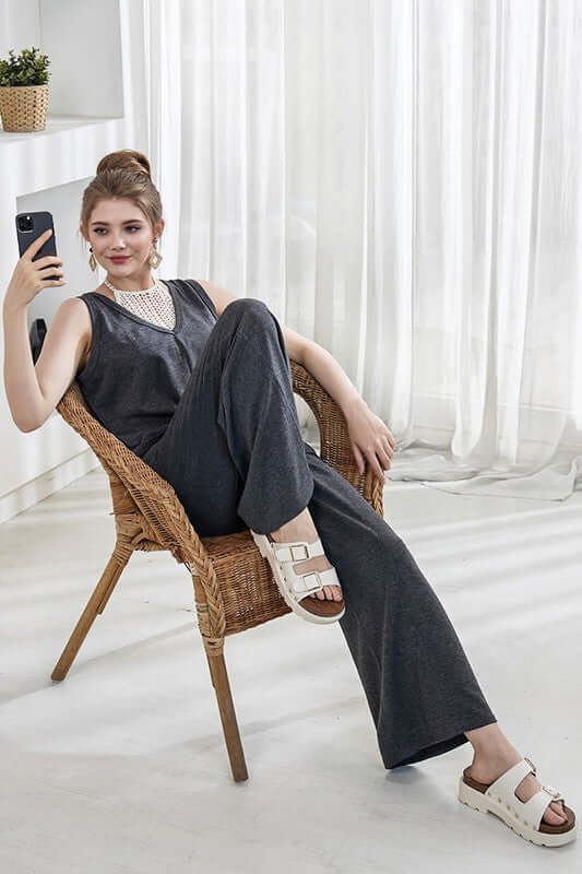 Oversized Patched Pocket V-Neck Jumpsuit worn by a model sitting in a chair, featuring relaxed wide-leg design.