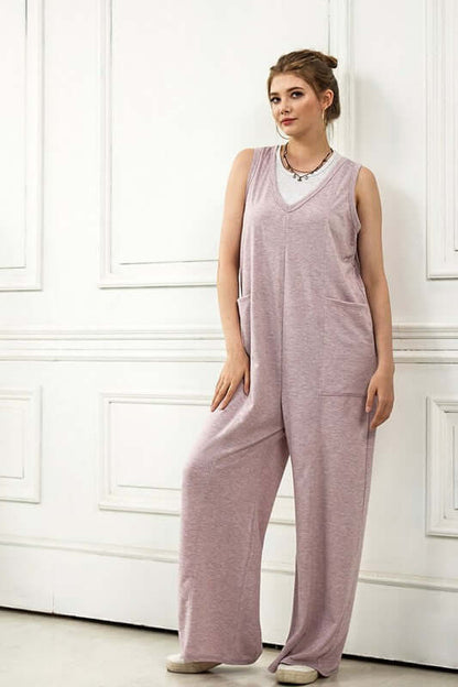 Model wearing an Oversized Patched Pocket V-Neck Jumpsuit in soft French terry fabric, showcasing wide-leg design.