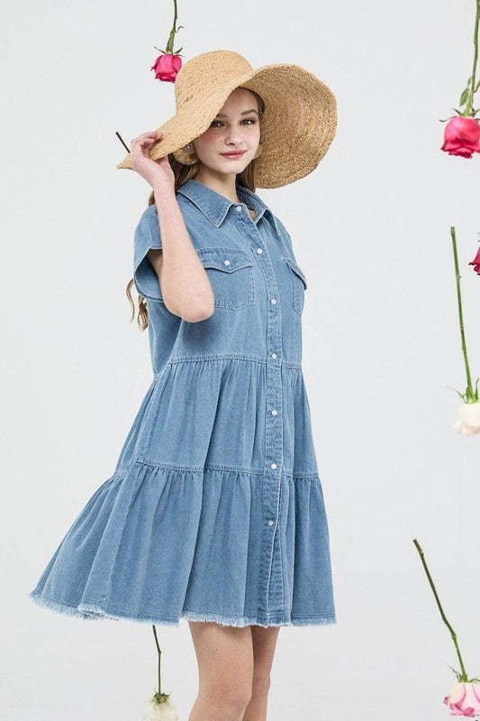 Button Down Tiered Babydoll Denim Shirt Dress worn by a model with a straw hat, showcasing its stylish design and A-line silhouette.