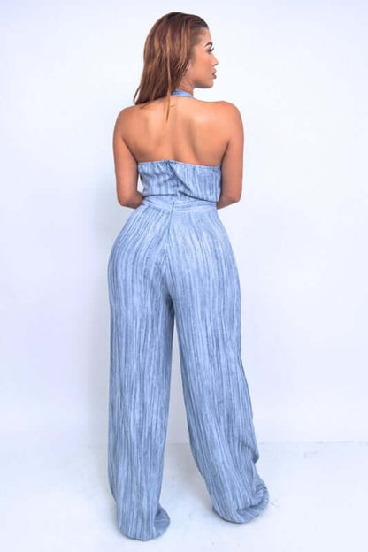 Back view of Skyline Halter Jumpsuit featuring wide-leg trousers and halter neck in textured blue fabric.