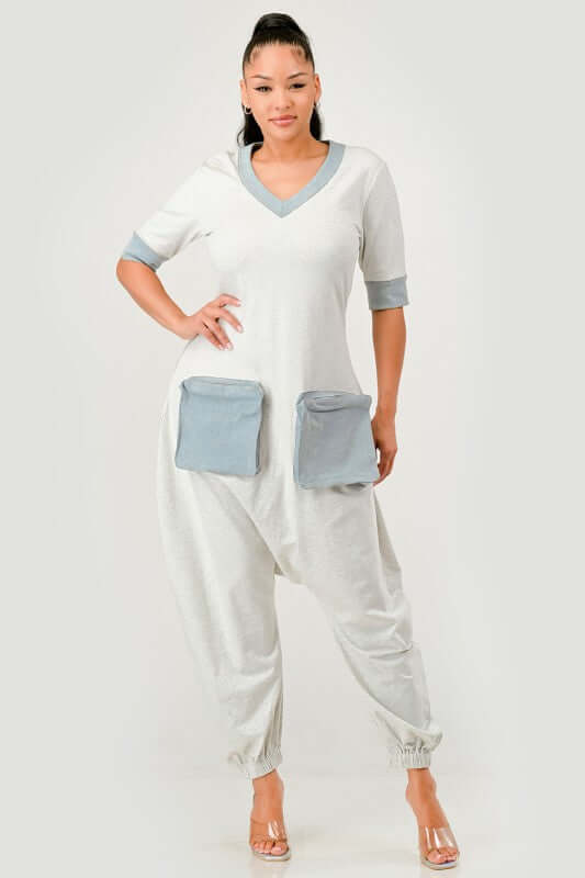 Stylish model wearing a Denim Accent Jumpsuit with V-neckline and oversized denim patch pockets.