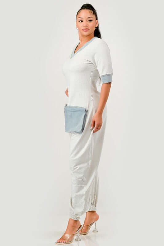 Model wearing a Denim Accent Jumpsuit with a V-neckline, denim accents, and oversized patch pockets.