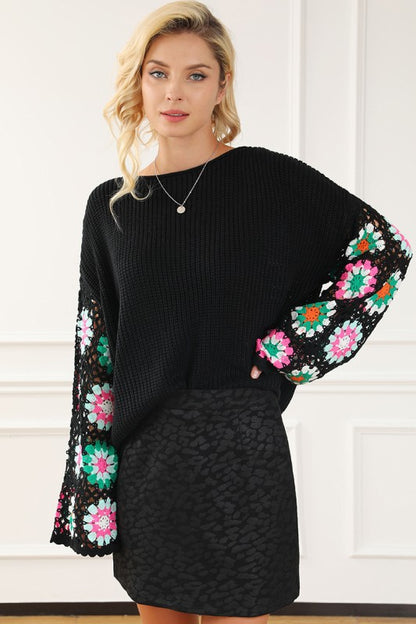 Black Floral Crochet Bell Sleeve Loose Sweater with delicate crochet sleeves and boat neckline, styled over a black skirt.