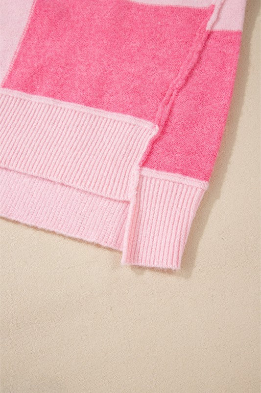 Close-up of pink hem on Abigail High Low Loose Sweater showcasing colorblocking and striped pattern.