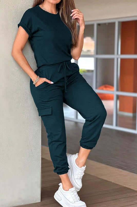 Model wearing a Crew Neck Short Sleeve Drawstring Waist Jumpsuit in dark color, perfect for casual outdoor occasions.
