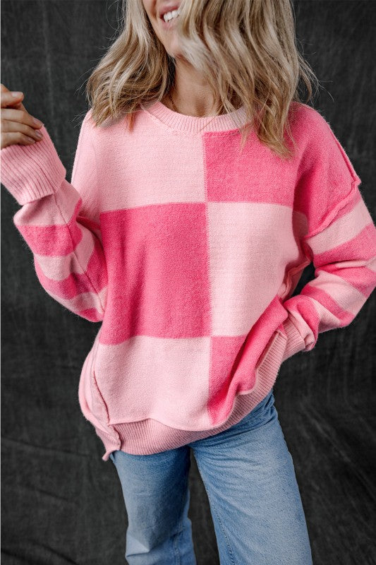 Woman wearing Abigail High Low Loose Sweater in pink with colorblocking, featuring a relaxed fit and modern asymmetric silhouette.