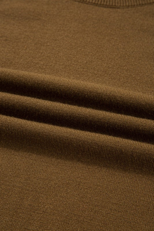 Close-up texture of Colorblock Raglan Puff Sleeve Mock Neck Sweater in brown fabric.