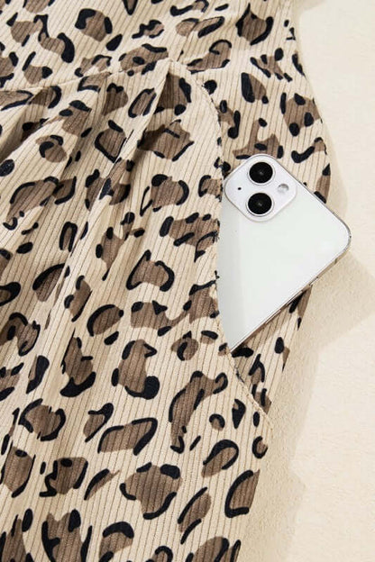 Leopard Bib Wide Leg Jumpsuit close-up, showcasing bold leopard print fabric and a smartphone pocket.