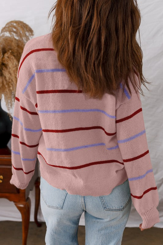 Rear view of Stripe Ribbed Trim Drop Shoulder Sweater in pink with red and blue stripes on back, paired with jeans in a casual setting.