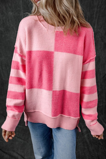 Woman wearing Abigail High Low Loose Sweater in pink with striped and colorblock design, showcasing a relaxed fit and high-low hem.