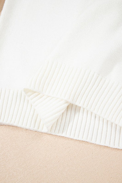 Close-up of Avery Print Drop Shoulder Sweater hem in cozy knit fabric, showcasing ribbed texture and soft white color.